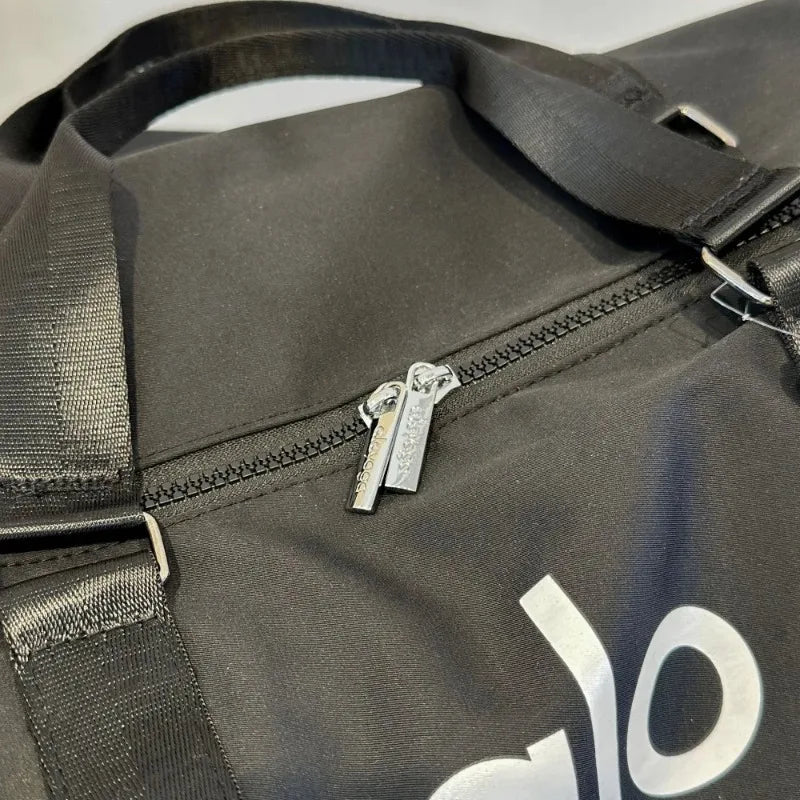 Close-up of dual zipper on black travel gym bag with adjustable strap