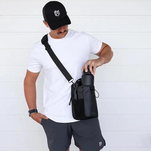 Man wearing black magnetic gym bag crossbody style with water bottle holder and adjustable shoulder strap