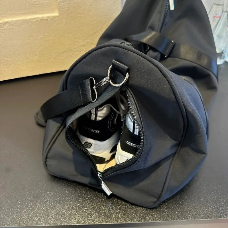 Black gym bag with separate shoe compartment holding sneakers